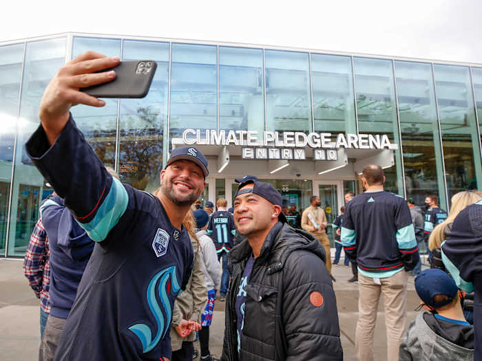 Seattle Kraken fans take a selfie outside Climate Pledge Arena before a game between the Kraken and the Vancouver Canucks.